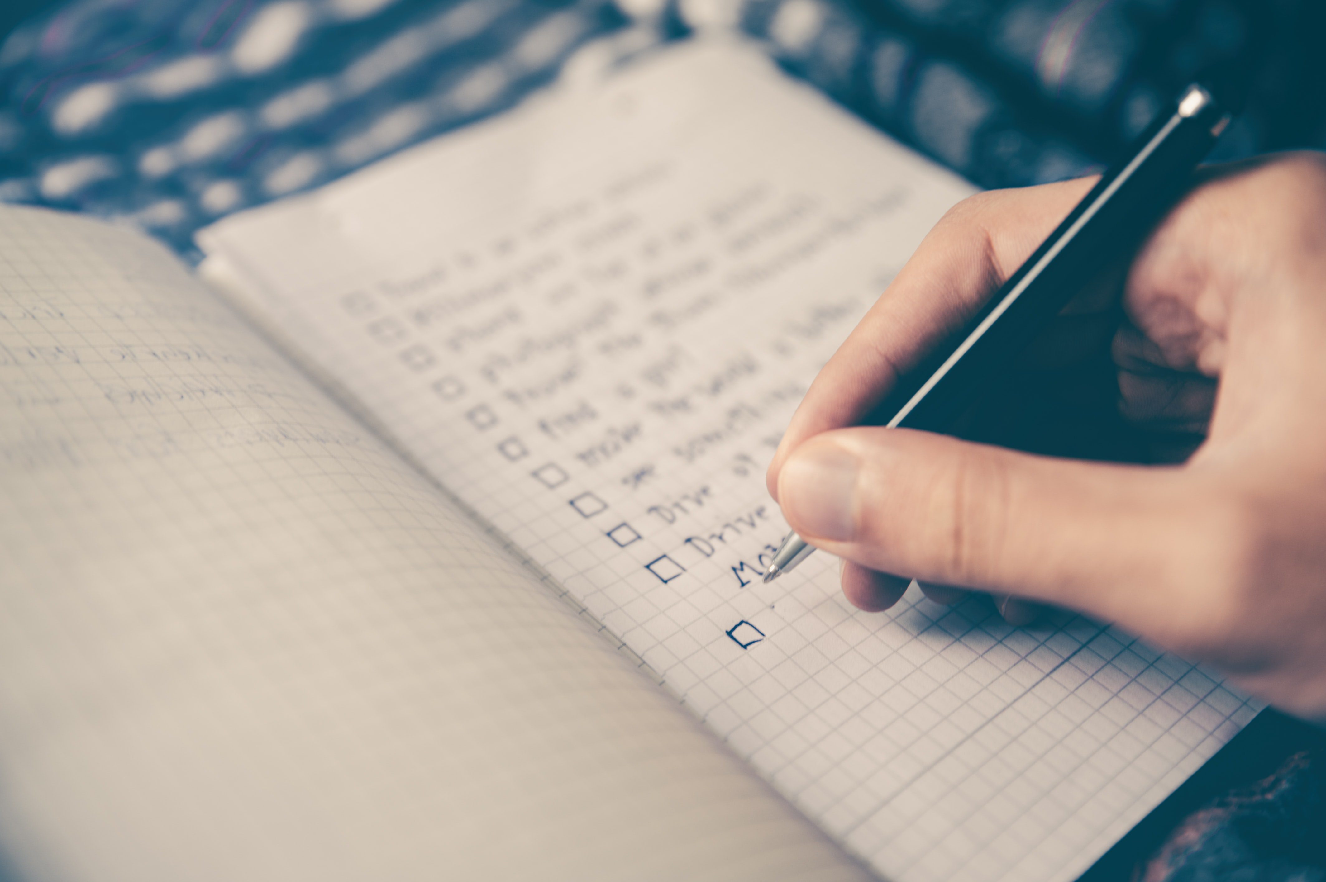 A person writing a checklist for their group facilitation.
