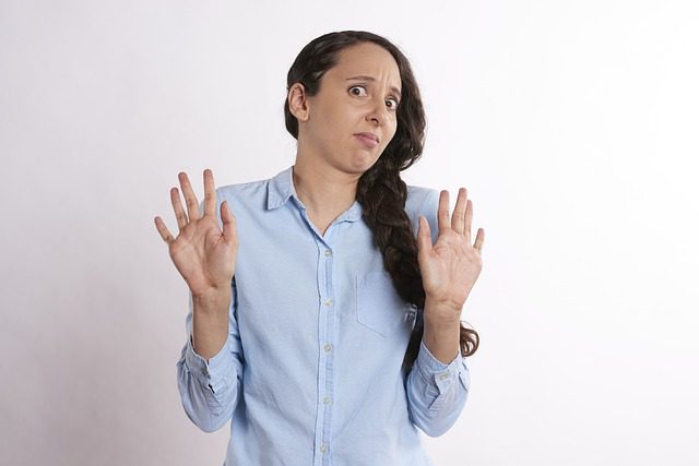 A person with their hands up in the denial stage of the grieving process.